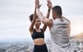 Thank you for being my best motivator. a sporty young couple high fiving each other while exercising outdoors.
