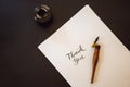 Thank you. Calligrapher Young Woman writes phrase on white paper. Inscribing ornamental decorated letters. Calligraphy Royalty Free Stock Photo