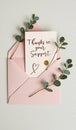Thank you card in pink envelope with greenery accents on white background Royalty Free Stock Photo