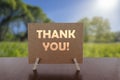 Thank you card on the table with sunny green park background Royalty Free Stock Photo
