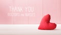 Thank You Doctors and Nurses message with a red heart cushion