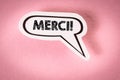 THANK YOU in French. Text on speech bubble. Pink background Royalty Free Stock Photo