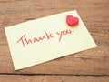 Thank you handwriting on post-it notes with red heart.