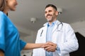 Thank you for help, colleague. Happy male doctor shaking hand of female coworker in clinic Royalty Free Stock Photo