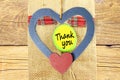 Thank you letter tag or label with heart in jute and wooden background Royalty Free Stock Photo