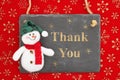 Thank you message on a chalkboard sign with a snowman