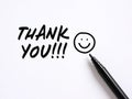 Thank you message with a hand drawn smiling emoticon face on white background. Gratitude concept