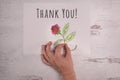 Thank You! message with hand sketched rose real hand holding flower stem