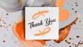 Thank you message on paper card note over muted orange and creamy gray background, AI