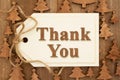 Thank You message on a wood gift tag over trees