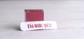 Thank you note in front of a red gift box