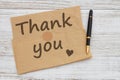 Thank you note with pen on brown crumpled paper on weathered wood Royalty Free Stock Photo