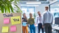 Thank you notes on a board in a modern office with colleagues chatting in the background, celebrating appreciation and Royalty Free Stock Photo