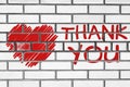 Thank you phrase and red heart painted on bricks wall