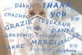 Thank you text on different world global languages with tired female nurse doctor or medical worker in ppe facemask on