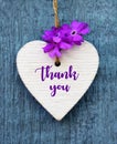 Thank You or thanks greeting card with flower and decorative white heart on blue wooden background.International Thank You Day. Royalty Free Stock Photo