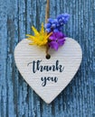 Thank You or thanks greeting card with flowers and decorative white heart on blue wooden background.International Thank You Day. Royalty Free Stock Photo