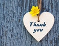 Thank You or thanks greeting card with yellow flower and decorative white heart on blue background.International Thank You Day. Royalty Free Stock Photo