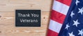 Thank You Veterans text written in chalkboard with flag of the United States of America on wooden background. Royalty Free Stock Photo