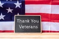 Thank You Veterans text written in chalkboard with flag of the United States of America on wooden background. Royalty Free Stock Photo