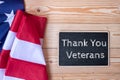 Thank You Veterans text written in chalkboard with flag of the United States of America on wooden background. Royalty Free Stock Photo