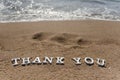 Thank you word drawn on the beach sand