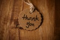 Thank you word written in a card on wooden background. Love and gratitude concept.