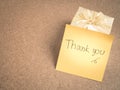 Thank you words on sticky note with gold gift box on wood backgr Royalty Free Stock Photo