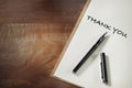 Thank you words written on notebook with fountain pen on working desk Royalty Free Stock Photo