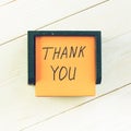 Thank you written on post note sticker on light wooden table, to Royalty Free Stock Photo