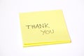 Thank you written on a post-it or a sticky note, isolated on white