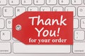 Thank you for your order message on a gift tag on gray keyboard