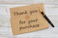 Thank you for your purchase message on brown crumpled paper with a pen on weathered wood Royalty Free Stock Photo