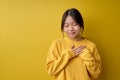 Thankful kind chinese female keeping hands on chest expressing gratitude