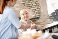 Thankful pensioner smiling while speaking with nurse Royalty Free Stock Photo