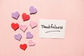 Thankfulness - text on paper with pink background and beautiful hearts