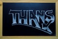 Thanks inscription by white chalk on black chalkboard. Thanks word in wooden frame