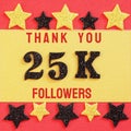 Thanks 25K, 25000 followers. message with black shiny numbers on red and gold background with black and golden shiny stars Royalty Free Stock Photo