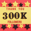 Thanks 300K, 300000 followers. message with black shiny numbers on red and gold background with black and golden shiny stars Royalty Free Stock Photo