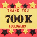 Thanks 700K, 700000 followers. message with black shiny numbers on red and gold background with black and golden shiny stars Royalty Free Stock Photo