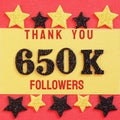 Thanks 650K, 650000 followers. message with black shiny numbers on red and gold background with black and golden shiny stars