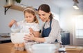 Thanks for letting me help out, mom. an adorable little girl assisting her mother while baking at home. Royalty Free Stock Photo