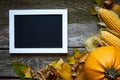 Thanksgiving autumn background on a dark wooden surface, pumpkins, withered leaves, acorns, chestnuts and a frame for