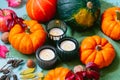 Thanksgiving autumn harvest composition with decorative pumpkins, apples, nuts, fallen leaves and burning candles on Royalty Free Stock Photo