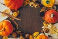 Thanksgiving background with autumn dried flowers, pumpkins and fall leaves on the old wooden background. Abundant harvest concept