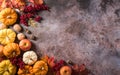 Thanksgiving background concept with fall leaves, pumpkin and seasonal autumnal decor on dark stone background, top view, copy