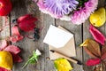 Thanksgiving background with seasonal fruits, flowers, greeting card and envelope on a rustic wooden table. Autumn harvest concept Royalty Free Stock Photo