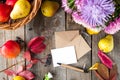 Thanksgiving background with seasonal fruits, flowers, greeting card and envelope on a rustic wooden table. Autumn harvest concept Royalty Free Stock Photo