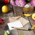 Thanksgiving background with seasonal fruits, flowers, greeting card and few craft envelopes on a rustic wooden table. Autumn harv Royalty Free Stock Photo