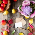 Thanksgiving background with seasonal fruits, flowers, greeting card, few craft envelopes on a rustic wooden table. Autumn harvest Royalty Free Stock Photo